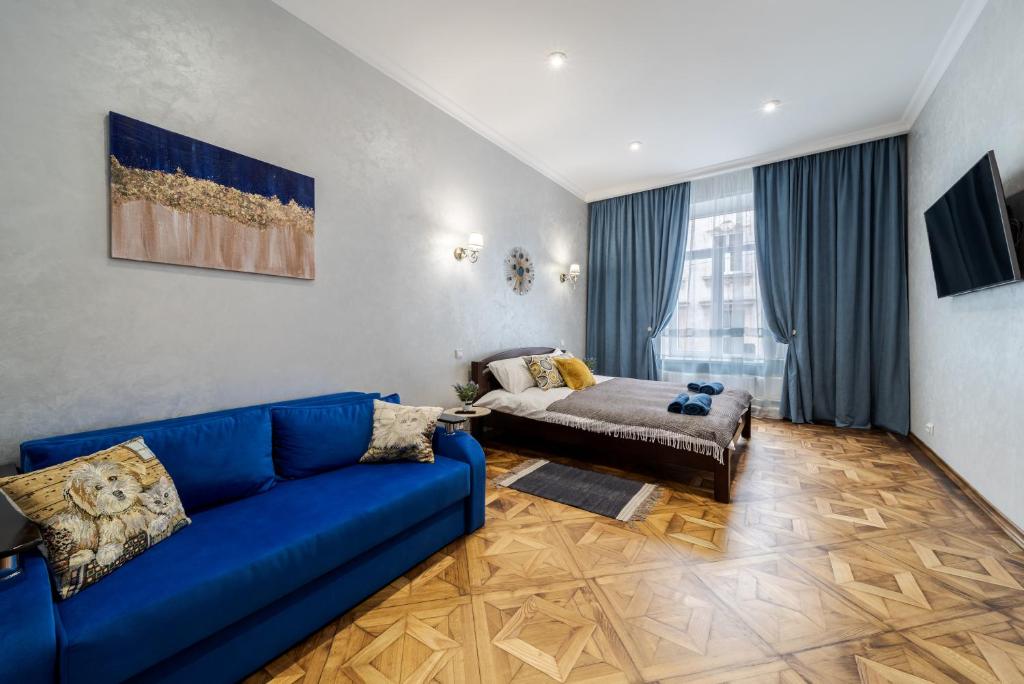 利沃夫Райська Насолода的客厅配有蓝色的沙发和床。