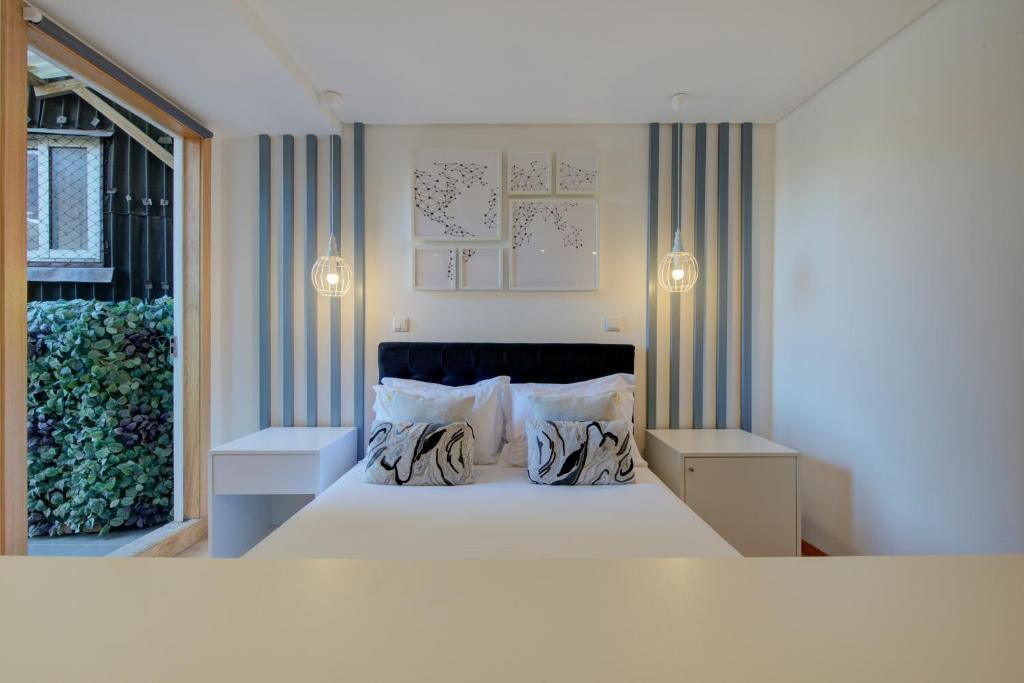 吉马良斯Bellu Suites的一间卧室配有一张大床和两个枕头