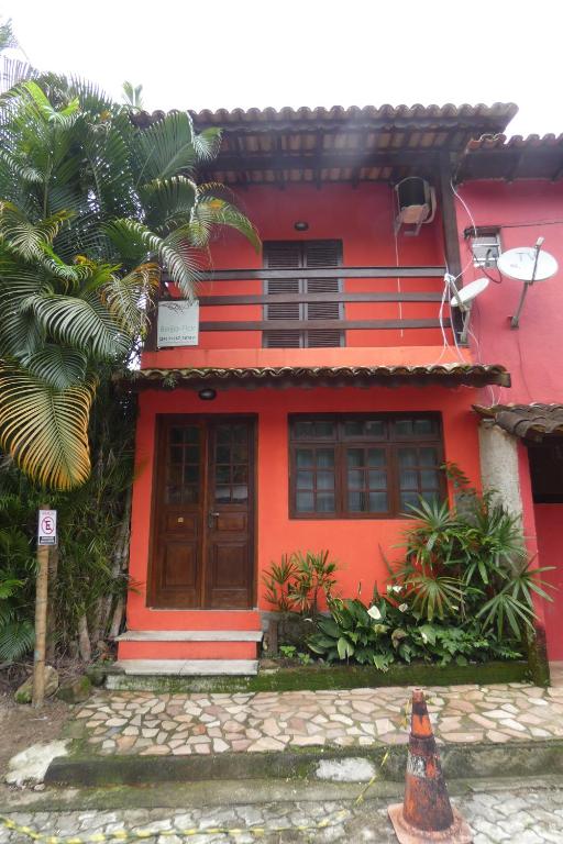 特林达德Casa Beija-Flor的前面有一只狗的红色房子