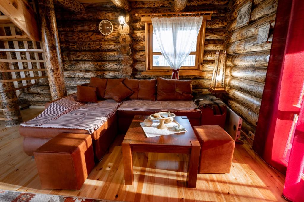 新瓦罗什Zlatarske brvnare Zlatar Chalets的小木屋内的客厅配有沙发和桌子