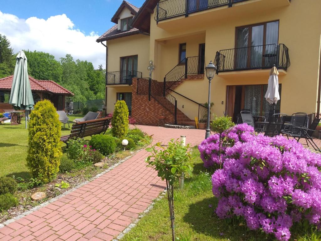 库多瓦-兹德鲁伊Apartamenty u Ani的紫色花朵和砖砌走道的房子