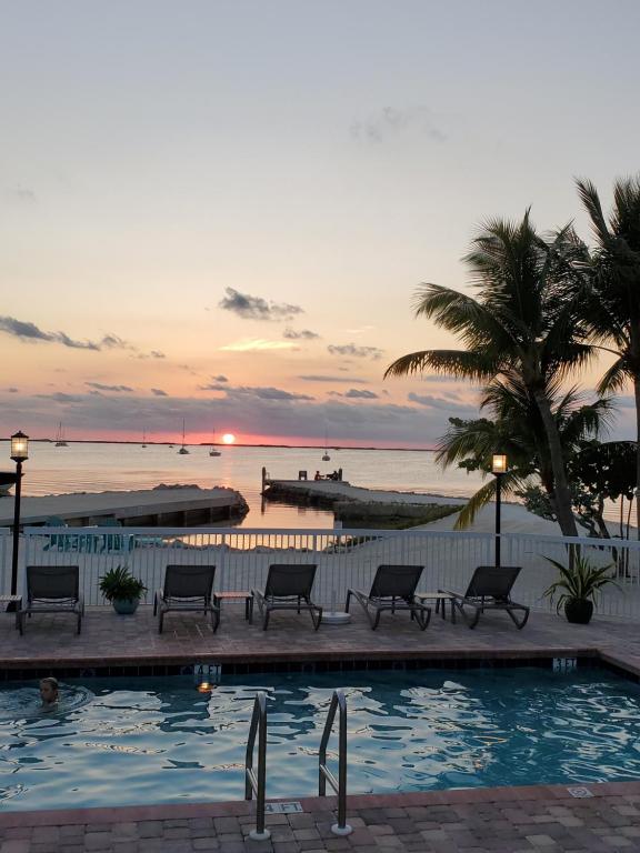基拉戈凯拉戈湾畔旅馆的日落时分带长椅和海洋的游泳池