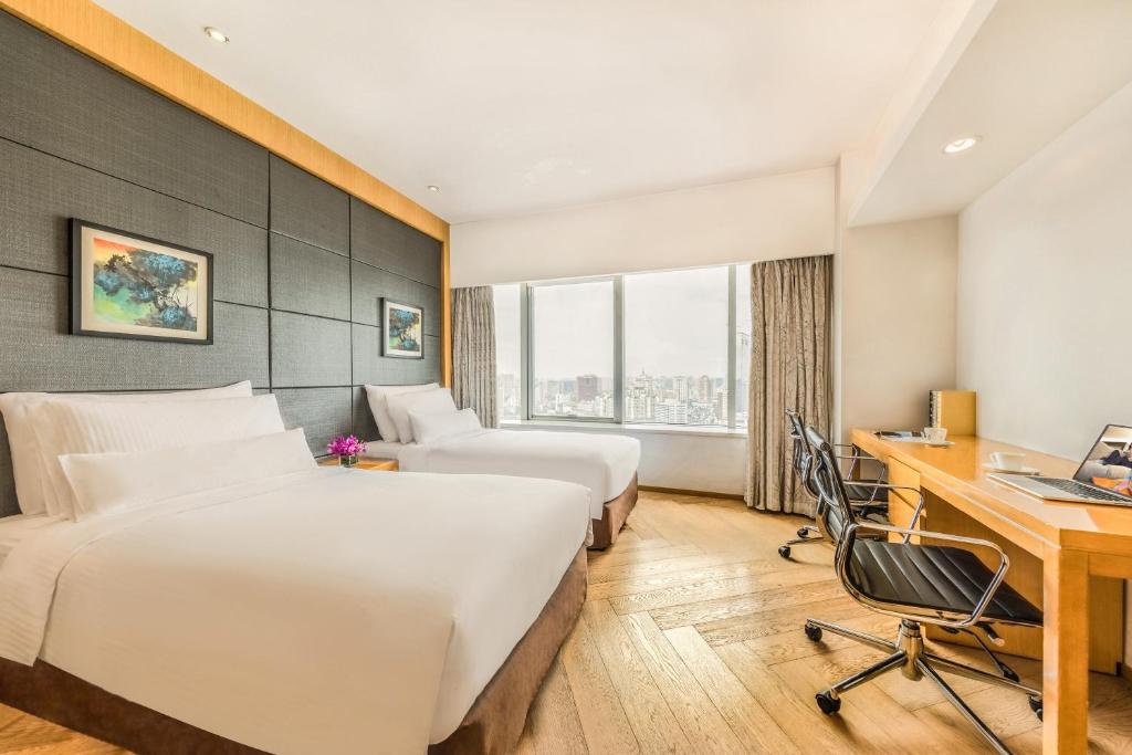 成都成都盛捷江畔服务公寓的酒店客房配有两张床和一张书桌