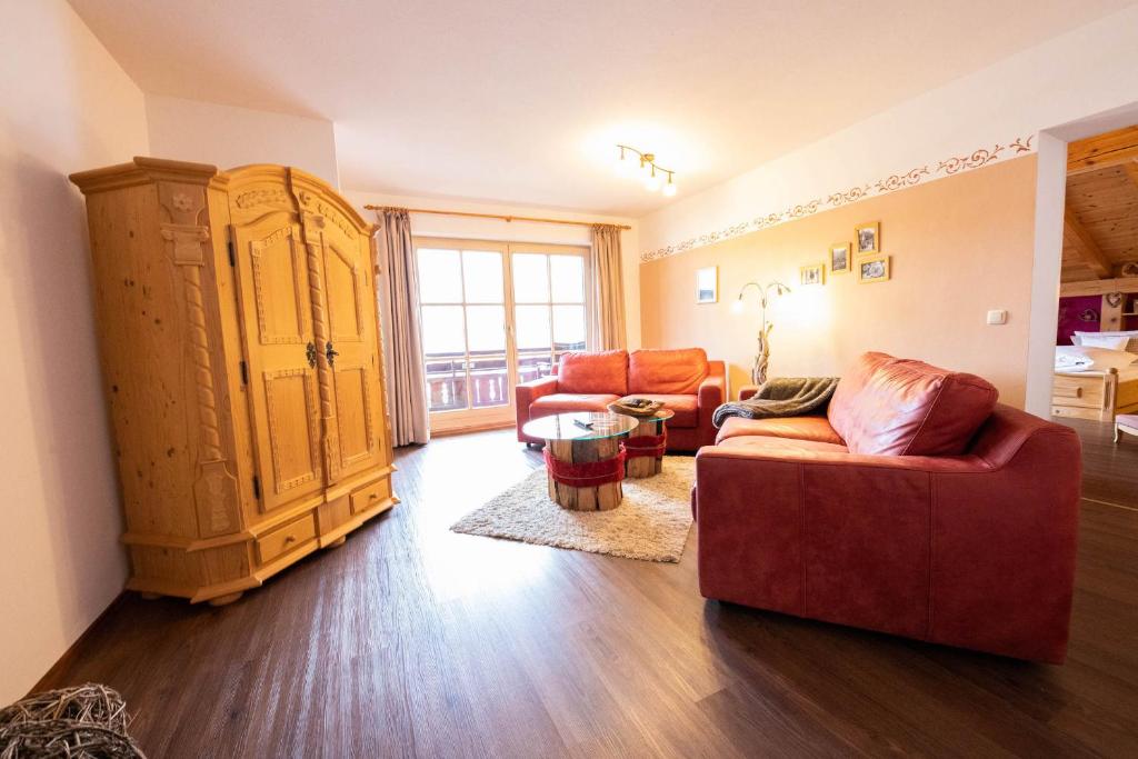 格赖瑙Edelrose的客厅配有红色沙发和大橱柜