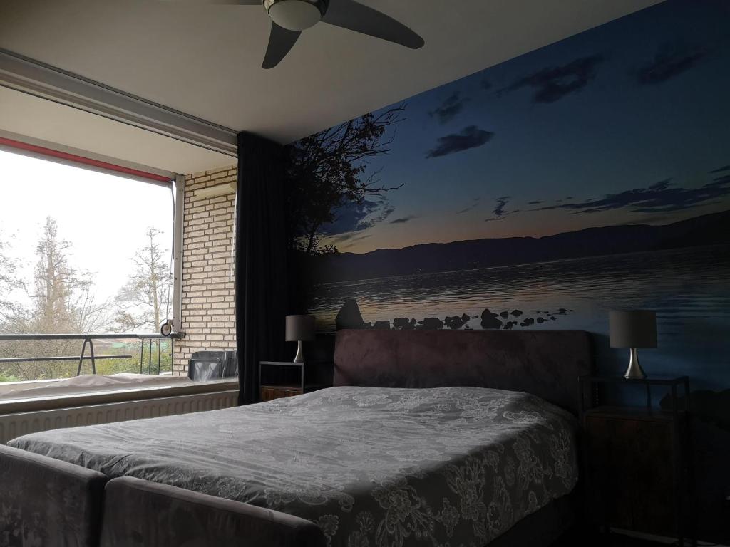 海牙Benvenuto的卧室配有一张床,墙上挂有绘画作品