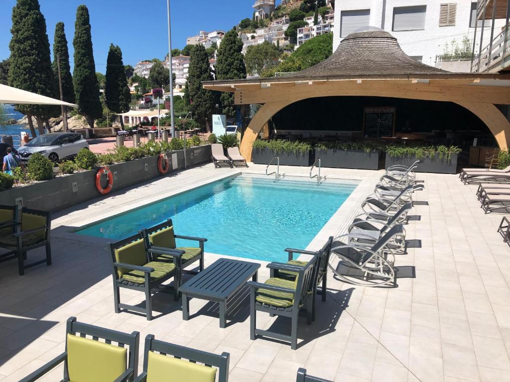 罗萨斯坎耶莱斯海滩酒店的一个带躺椅和凉亭的游泳池