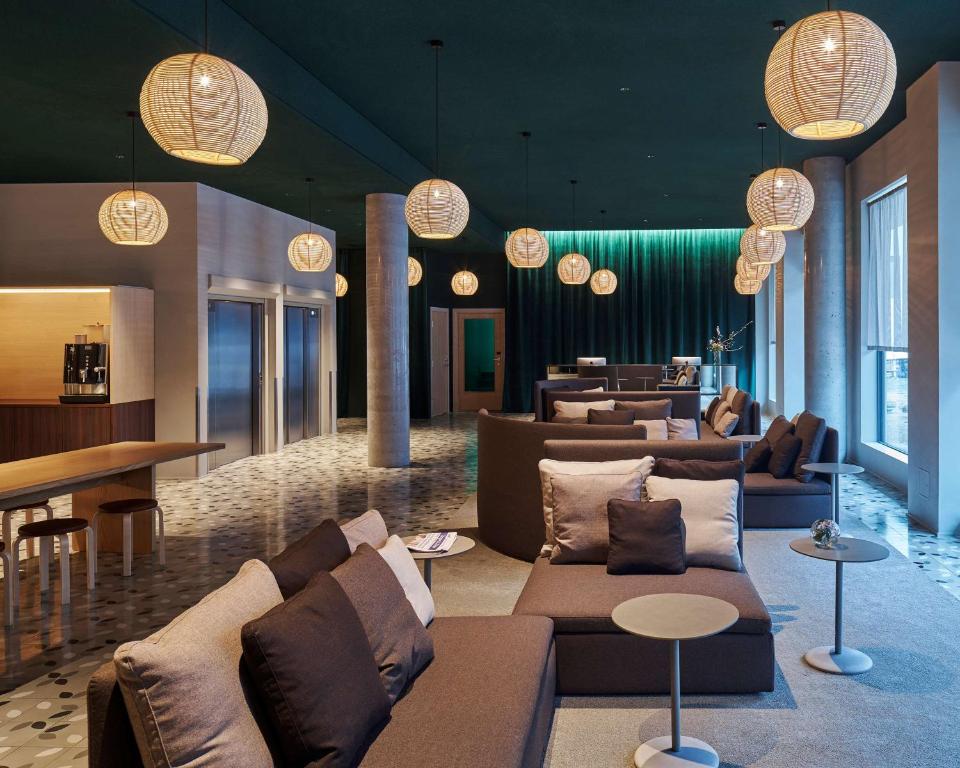 卑尔根桑德尔K酒店的大堂配有沙发、桌子和吊灯。