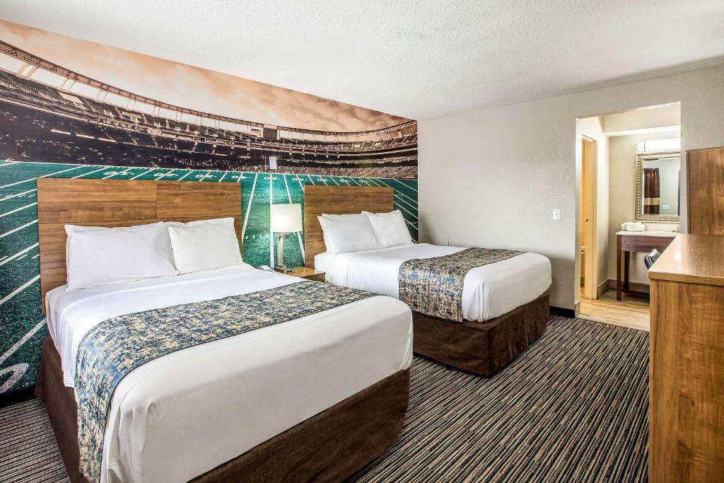 东兰辛Clarion Pointe East Lansing University Area的酒店客房设有两张床和电视。