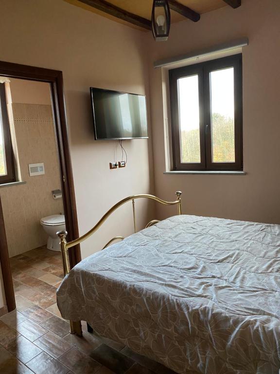 卡普拉尼卡Le case di Nonna Gina的一间卧室配有一张床、一个卫生间和一台电视。