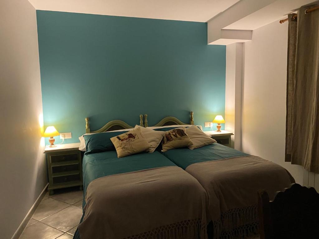 Sarroca de BelleraLa Fusteria del Casat的一间卧室配有一张蓝色墙壁的床