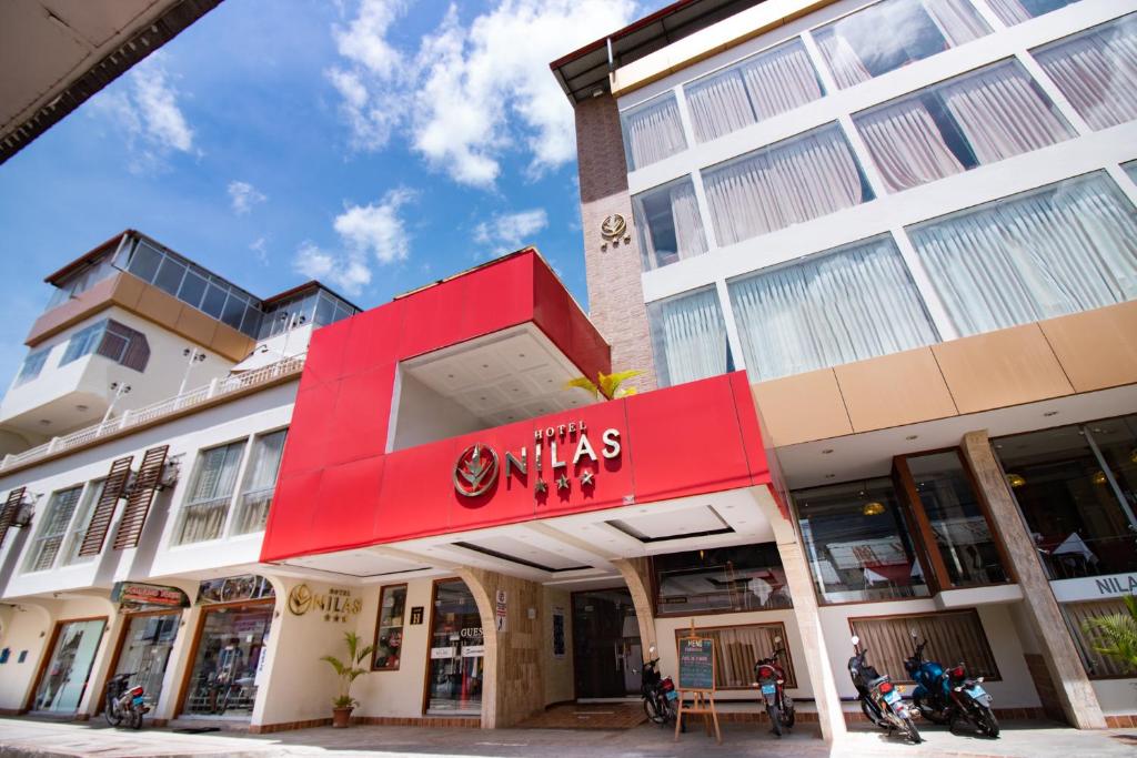 塔拉波托Hotel Nilas的前面有红色标志的建筑