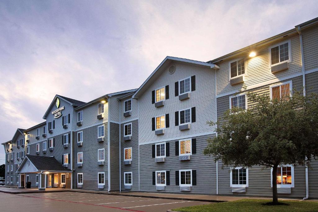 休斯顿WoodSpring Suites Houston Willowbrook的一座带灯的大型公寓楼