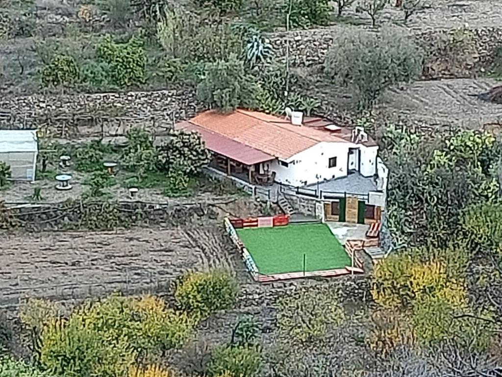 圣巴托洛梅Casa Rural La Hoyita de Tunte的享有绿色庭院房屋的空中景致