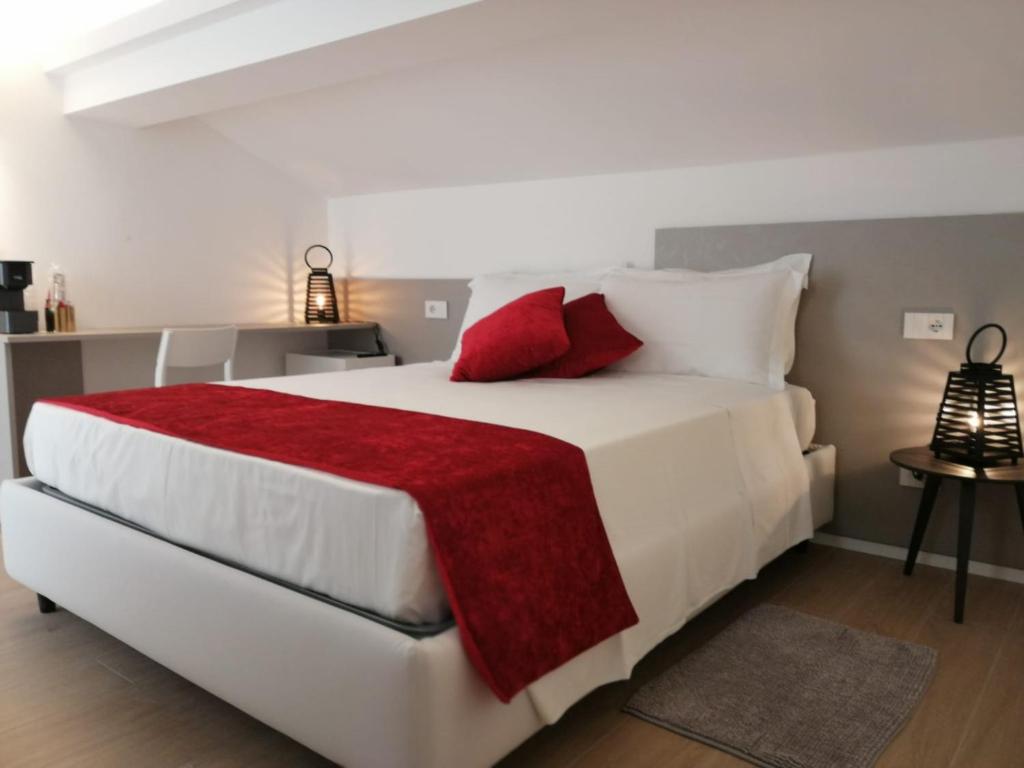 里乔内La Mansardina的卧室配有带红色枕头的大型白色床