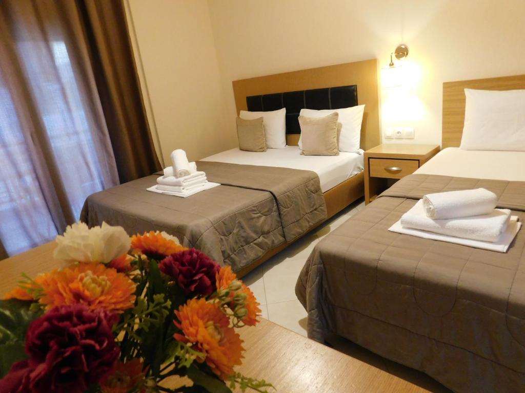 萨尔蒂Anna house 3的酒店客房设有两张床和一束鲜花