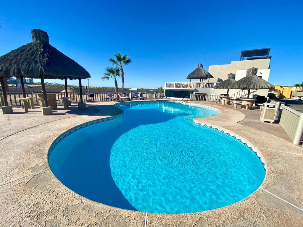 佩尼亚斯科港Bella Vista 7的一个带椅子和遮阳伞的蓝色游泳池