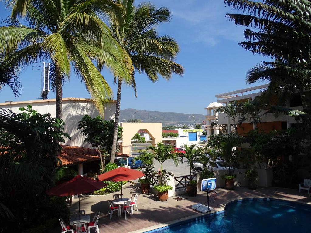 图斯特拉古铁雷斯Hotel Palapa Palace Inn的享有带游泳池和棕榈树的度假村的景致