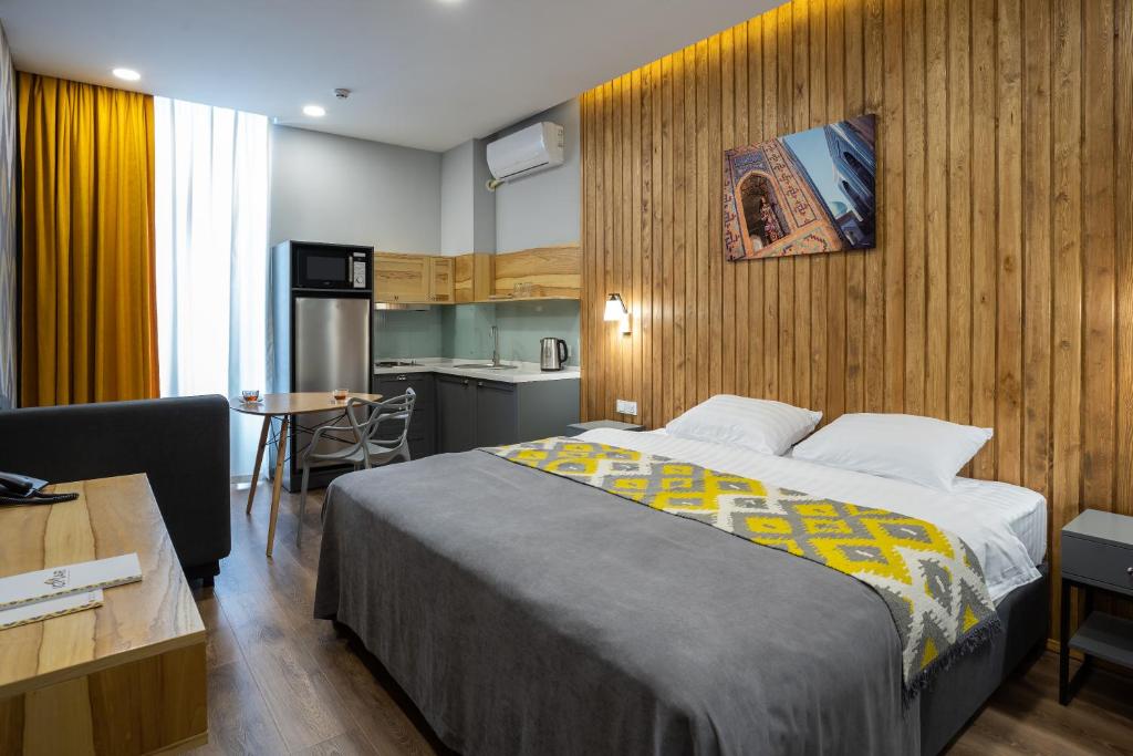 塔什干IGMAR Apart Hotel的酒店客房带一张床和一个厨房