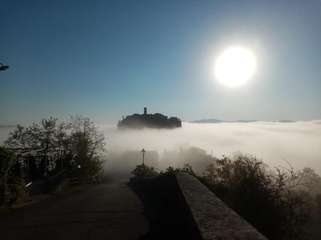 巴尼奥雷焦La Sorpresa Di Civita的享有一条有太阳背景的雾 ⁇ 道路的景色