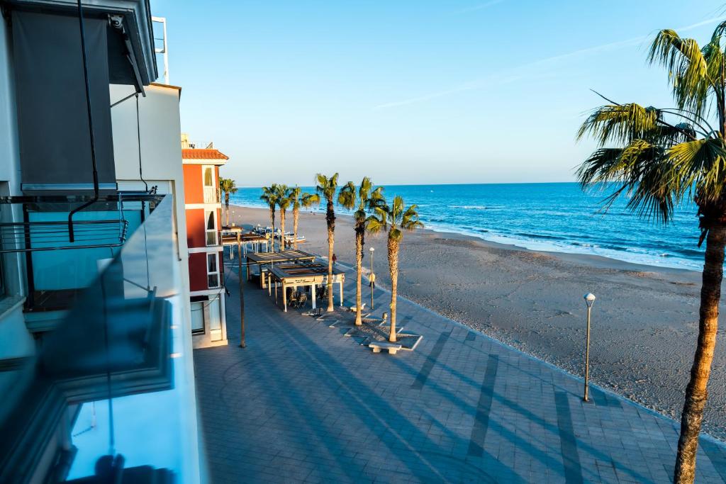 托里代巴拉Hauzify I Apartaments Grup Claustre的享有棕榈树海滩和大楼的景色