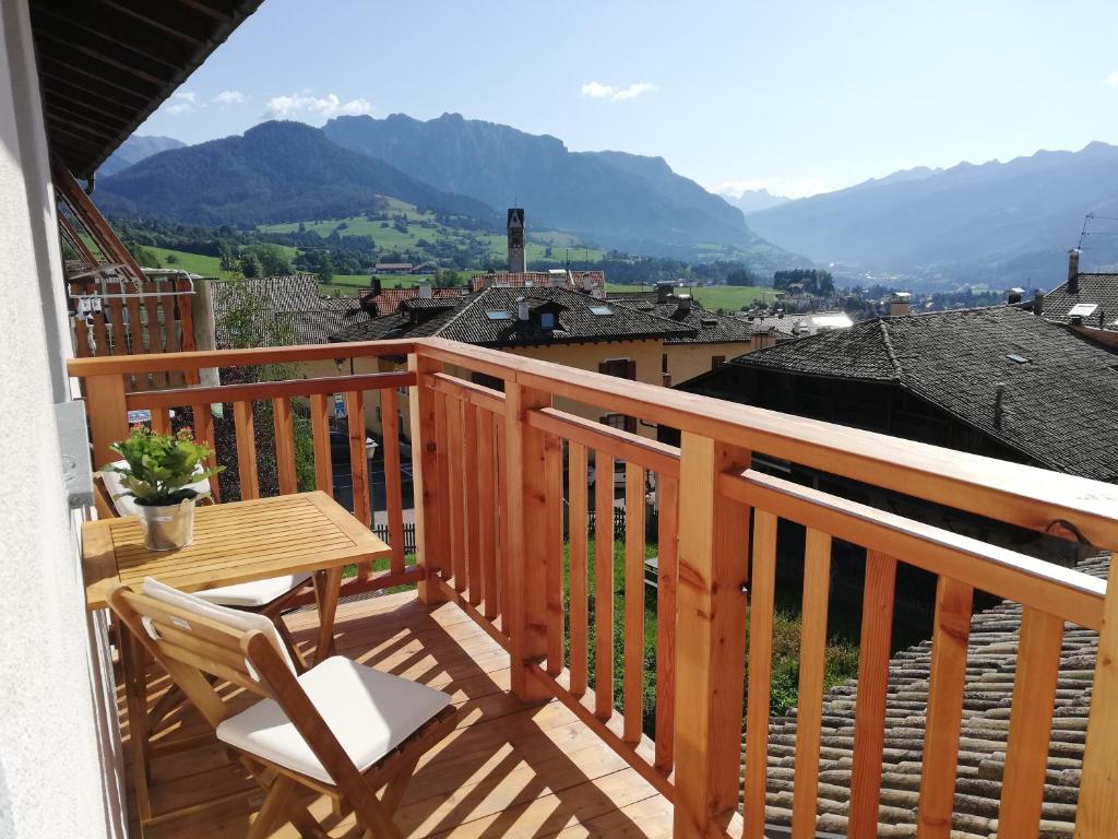卡拉诺Casa Lassù的木制阳台配有桌椅,享有山景。