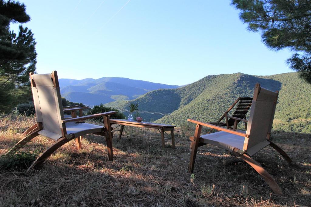 FellunsGites-Terroirs-Occitanie的两把椅子坐在山丘上,山背背景