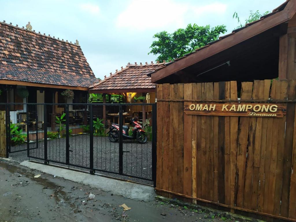 日惹Omah Kampong的木栅栏,门后有摩托车