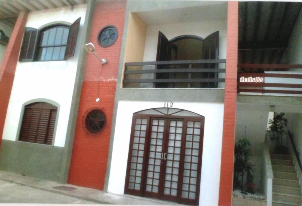 大伊瓜巴Apartamento Iguaba Grande, bairro Canellas City , em frente ao trailer do popeye的一座有门和钟的建筑
