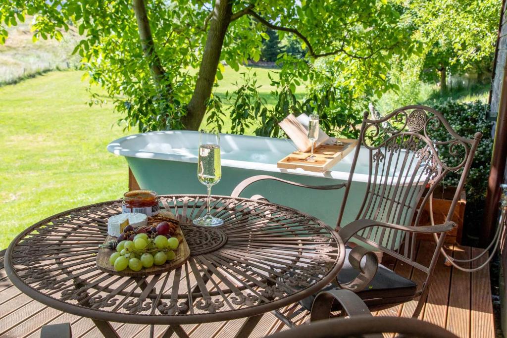 箭镇Arrowtown Country Cottage的一张桌子,上面有一篮葡萄和一个浴缸