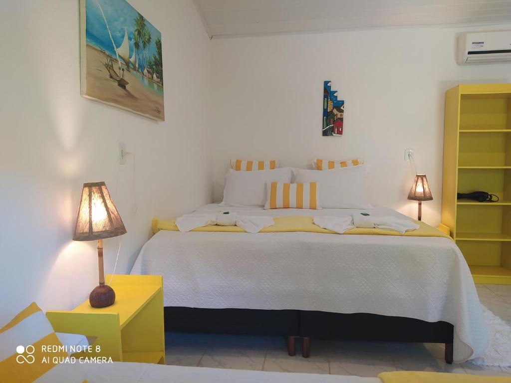 托兰克索Pousada João Maria的一间卧室配有一张白色大床和黄色橱柜