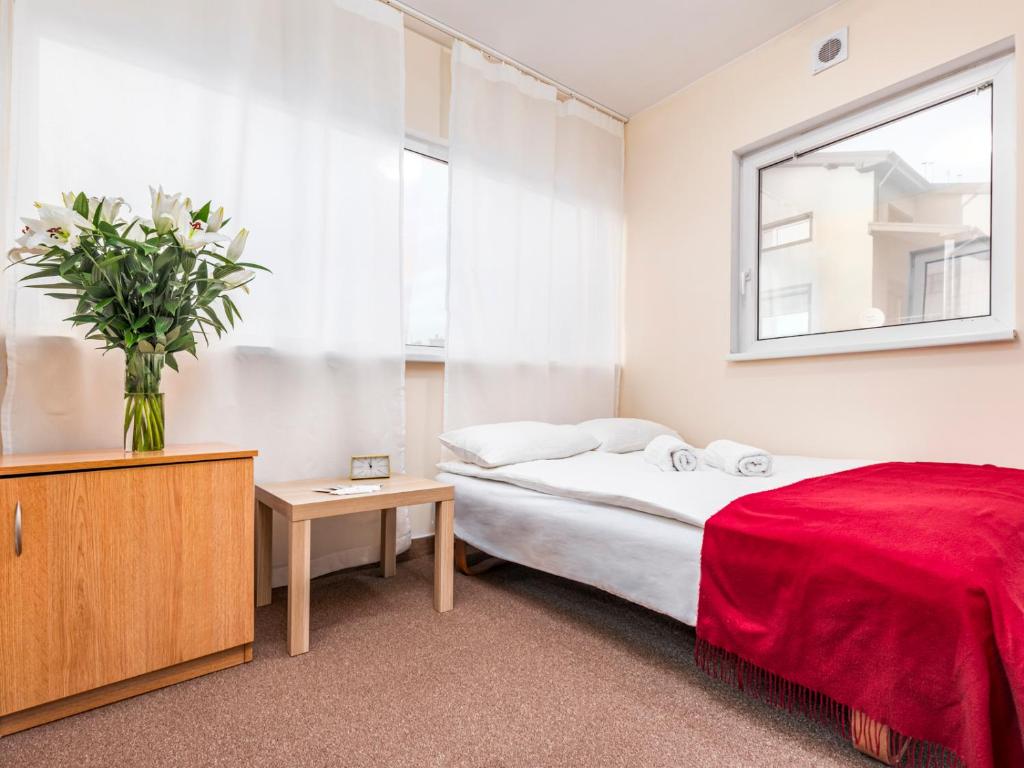 华沙Luxhostel24 Warsaw的一间卧室,配有一张床和花瓶