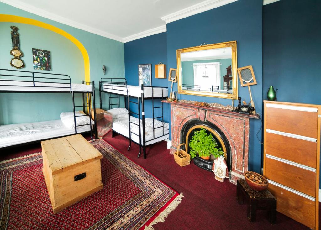 德罗赫达Spoon and the Stars Hostel的带壁炉的客房和带双层床的卧室。