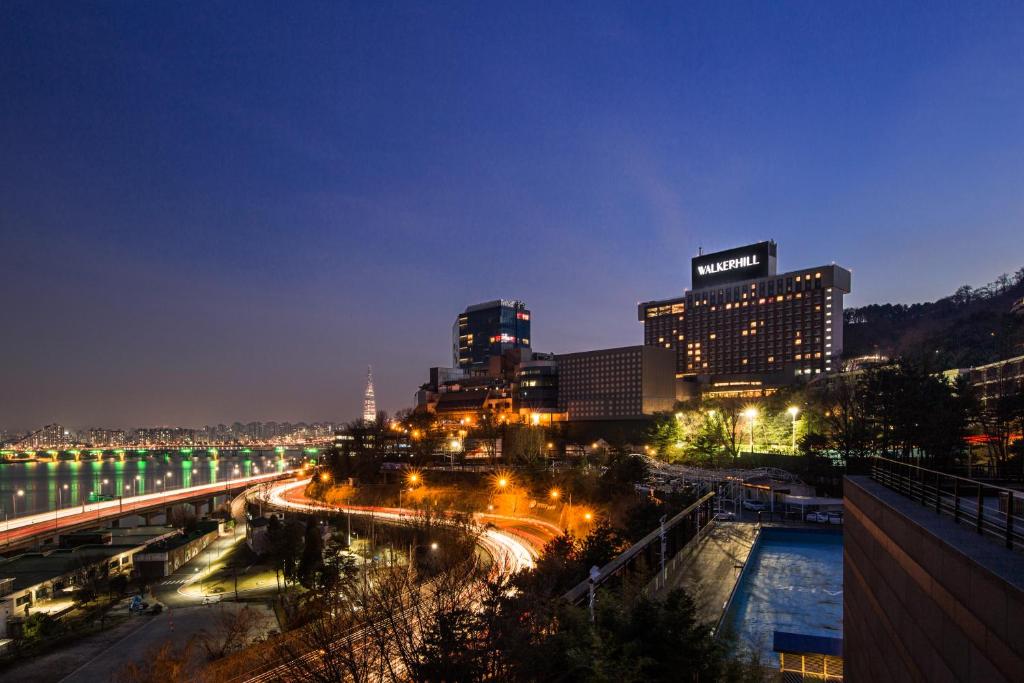 首尔华克山庄首尔大酒店的城市天际线,夜晚有河流和建筑