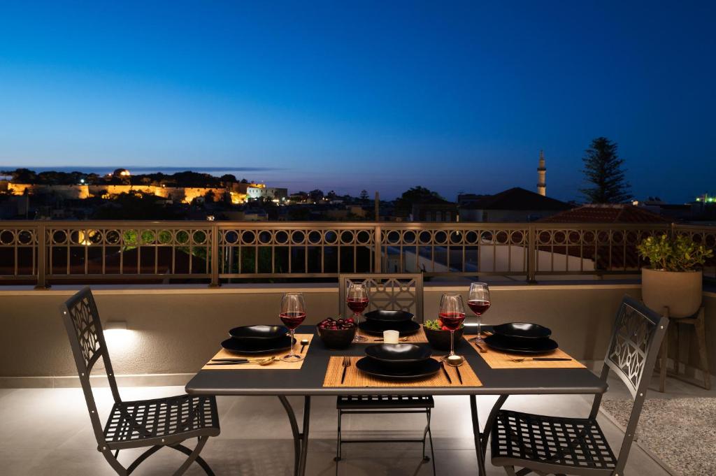 罗希姆诺Petalo Suites的阳台配有桌椅和酒杯