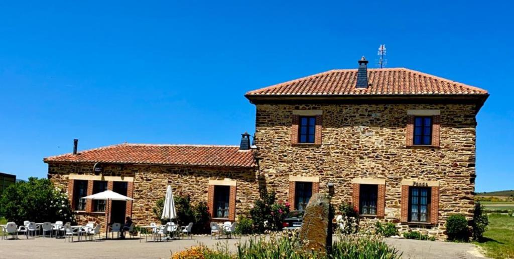 卢耶哥索摩查Hotel Rural Molino del Arriero的一座红色屋顶的大型石头建筑