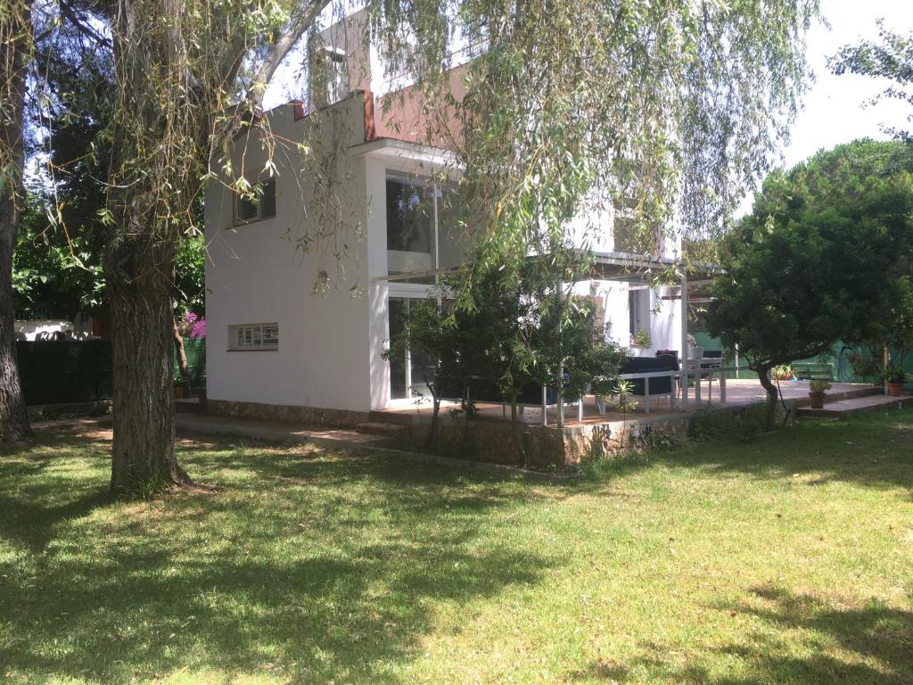 塔拉戈纳Casa con gran jardín cerca de la playa - BAIX 5 personas的院子里有树的白色房子