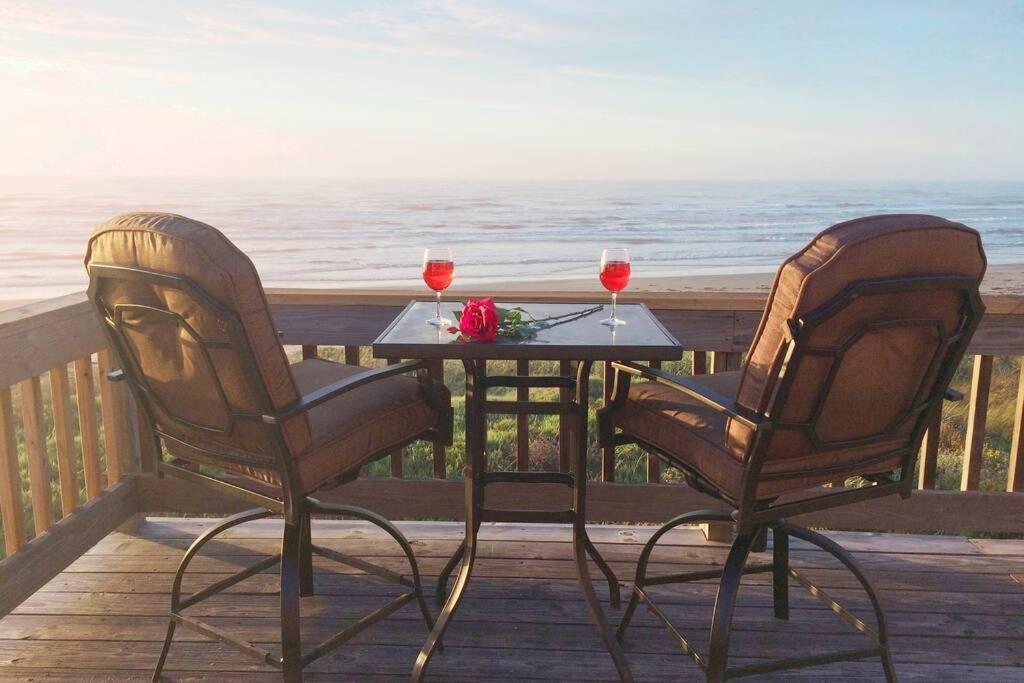 加尔维斯敦Beach Front on West Beach的两把椅子和一张桌子,两杯葡萄酒