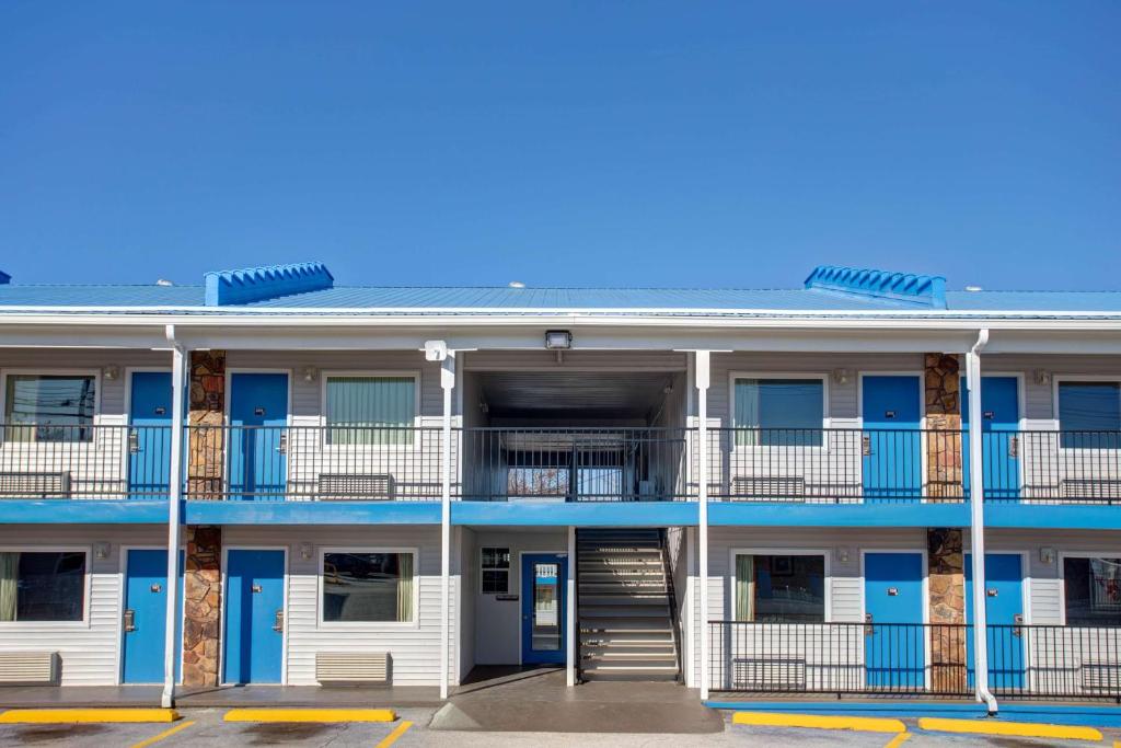 布兰森Motel 6 Branson, Mo的公寓大楼设有蓝色门和阳台。