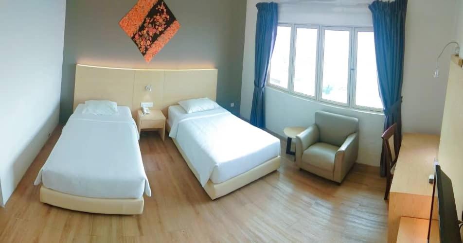 峇株巴辖峇株巴辖峰会西格尼酒店的一间卧室设有两张床、一把椅子和一个窗户。