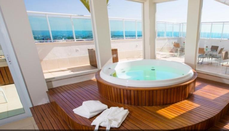 巴西利亚Flat Saint Moritz - Centro de Brasília A319的大型浴室设有大型浴缸,享有海景。