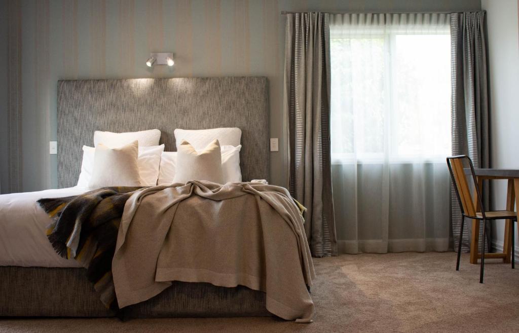 皇后镇皇后镇乡村旅舍的卧室配有带白色枕头的床和窗户。