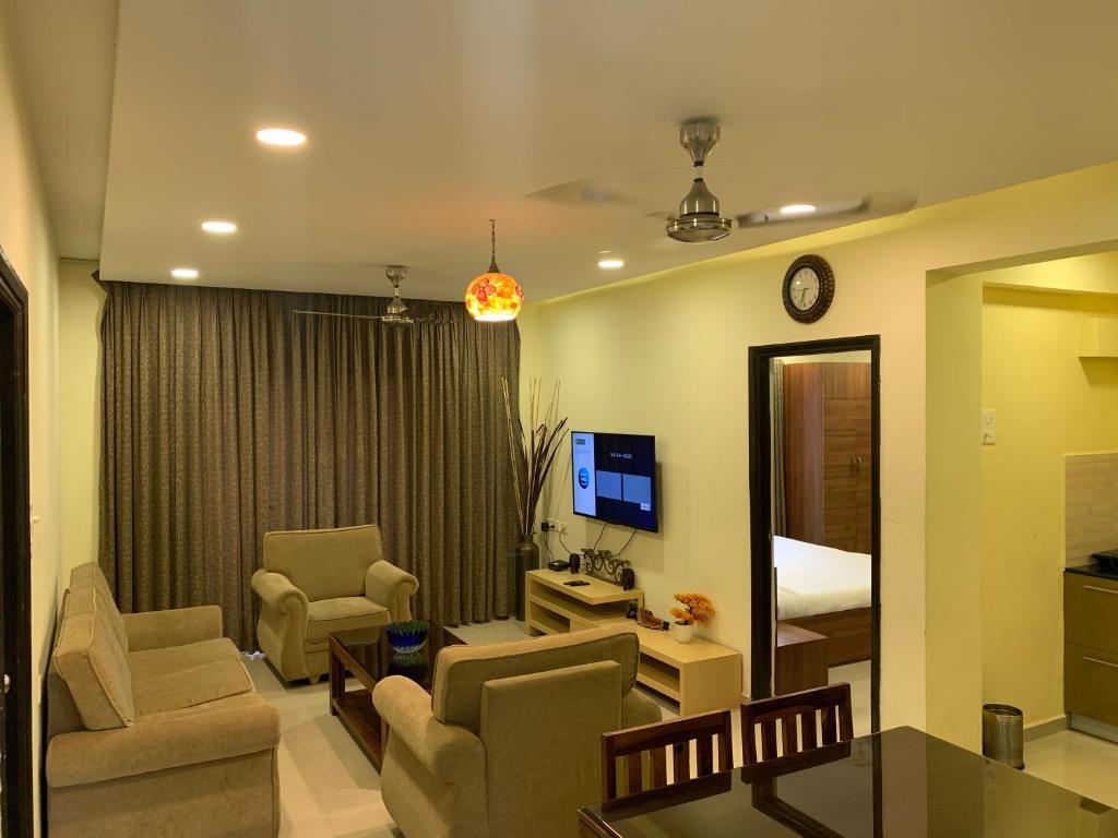 巴加Areia De Goa, Comfort Stay Apartment near Baga Beach的客厅配有沙发、椅子和镜子