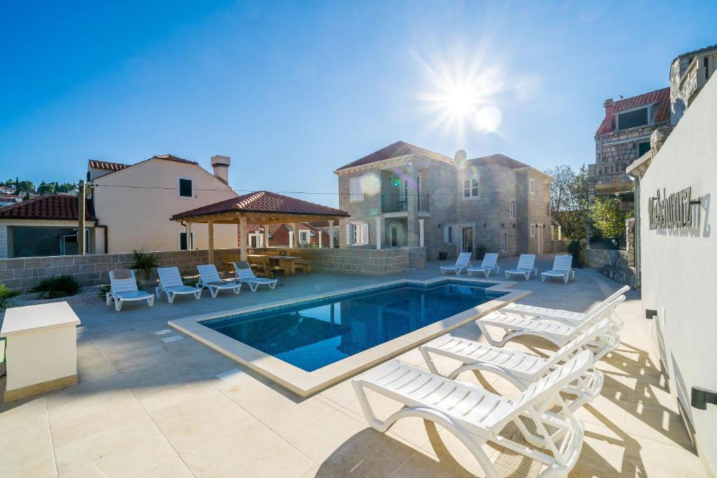 察夫塔特Residence & Pool Villa Schwarz Suites的一座带游泳池和两把躺椅的房子