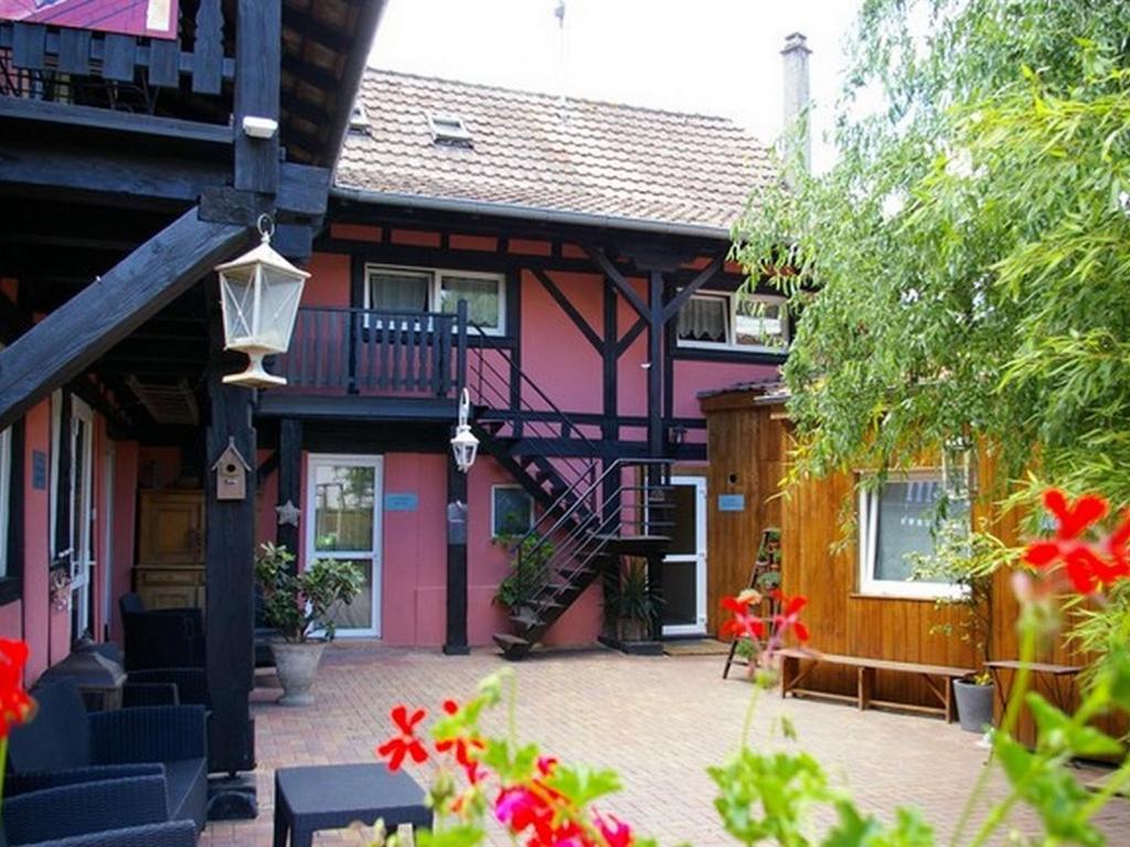 塞莱斯塔尚博勒斯迪霍特斯拉多马恩德斯勒姆帕尔斯酒店的粉红色的房子,庭院里设有楼梯