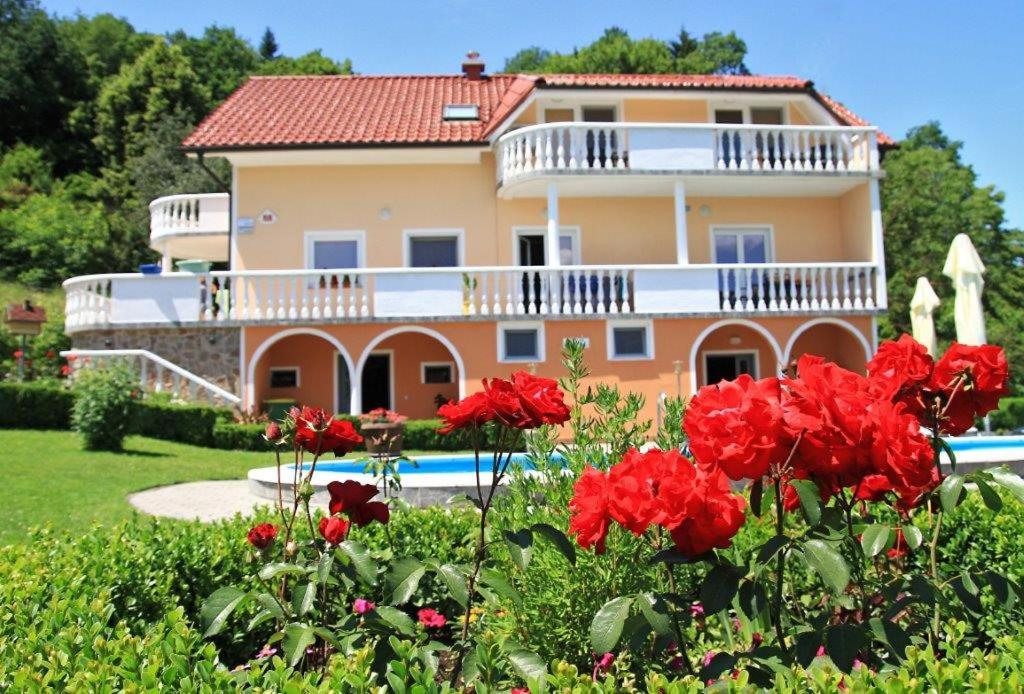 博德森特克Apartmaji in sobe Kocjančič的前面有红花的房子