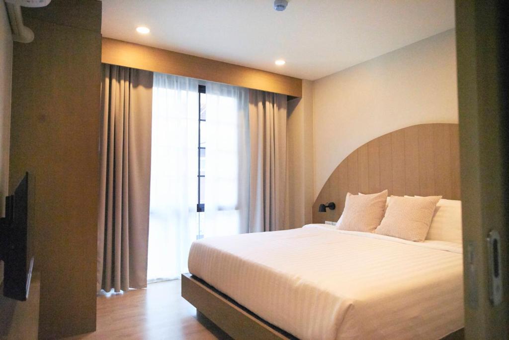 清迈Dream Nimman Apartment的一间卧室设有一张大床和一个大窗户
