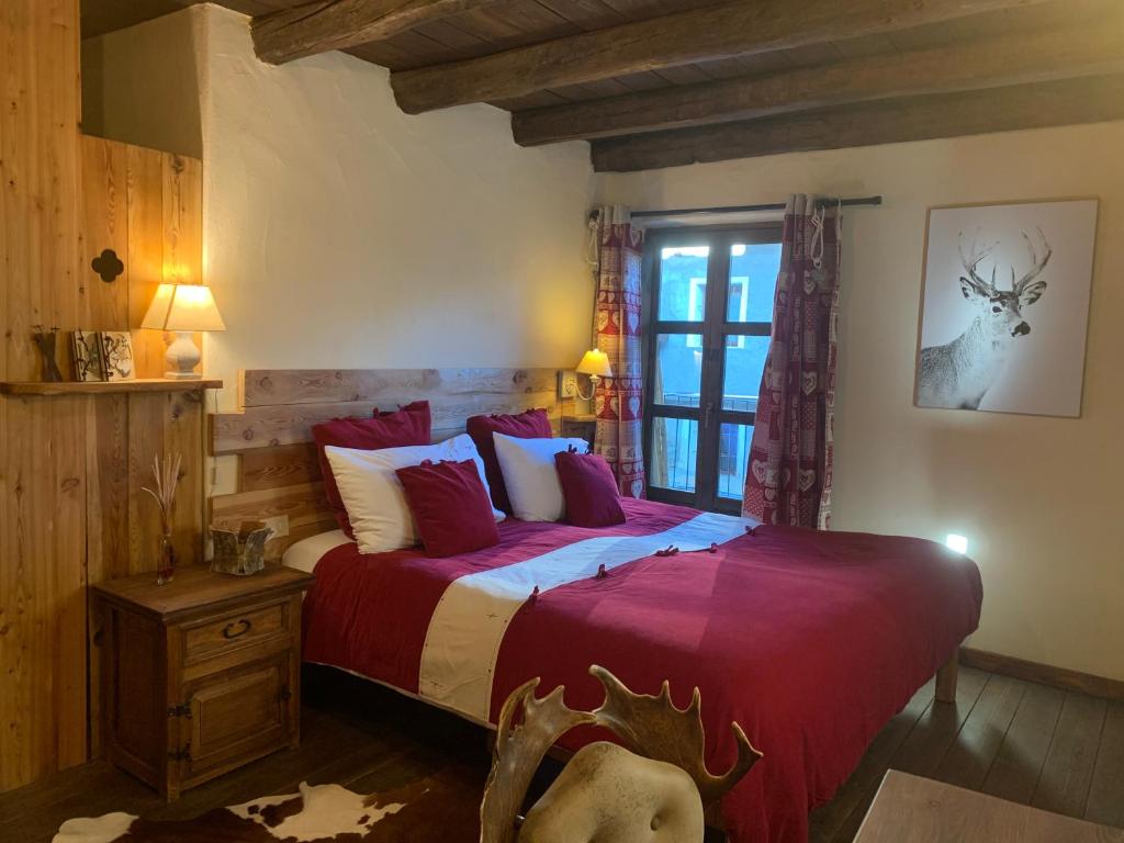 普拉吉拉托Locanda Allevè Hotel Ristorante的一间卧室配有一张带红色床单的床和一扇窗户。