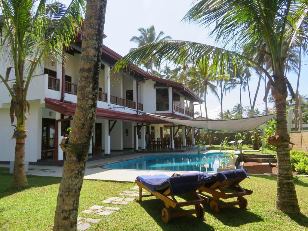 Paiyagala SouthThoduwawa Beach Villa的游泳池旁带吊床的房子
