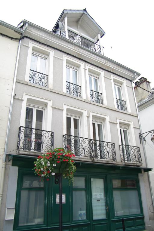 巴涅尔-德吕雄Maison hyper-centre Bagnères de Luchon的一座白色的建筑,设有阳台,上面有鲜花