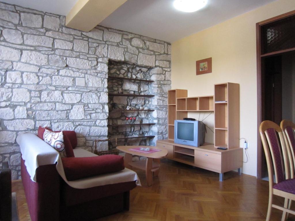拉茨斯切伊万公寓的客厅设有石墙和电视。